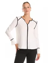 Blusa de crepe color blanco con ribetes en contraste color negro que recorren el escote, la línea central, los hombros y los puños. Presenta cuello redondo con abertura en V, mangas largas con puños abiertos y cierre con botón metálico, y un corte fluido con ruedo redondeado.