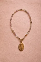 Collar compuesto por una cadena de piedras naturales facetadas en tonos translúcidos, beige y tierra, con un dije central de la Medalla Milagrosa en metal dorado.