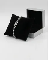Pulsera de acero inoxidable con diseño de tenis, compuesta por una hilera de circonias blancas y negras alternadas. Cuenta con cierre de seguridad.