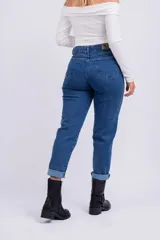 Pantalón de jean azul oscuro, corte mom, tiro alto y ruedo arremangado.
