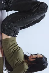 Jeans de tiro medio con diseño baggy barrel, confeccionados en denim color beige con efecto lavado. Presentan cinco bolsillos, costuras laterales torcidas y cierre frontal con cremallera y botón metálico.