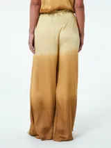 Pantalón palazzo celeste con degradé a gris y negro, de tiro alto con cintura elastizada y cordón ajustable.