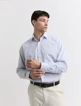 Camisa celeste y blanca a rayas verticales, de manga larga y corte clásico.