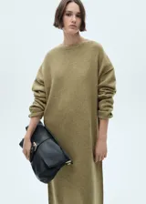 Vestido largo de punto con diseño recto, cuello redondo y manga larga con puños en canalé. Presenta una textura suave y un corte holgado.