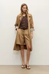 Short de lyocell color beige, de tiro alto y corte amplio, con pinzas delanteras y presillas para cinturón. Incluye un cinturón trenzado marrón oscuro con hebilla redonda forrada.
