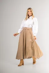 Camisa blanca con cuello alto con volados, cierre frontal con botones ocultos y mangas largas abullonadas.