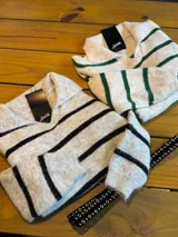 Sweater de punto con diseño a rayas horizontales en color gris y verde. Presenta cuello tipo polo con escote en V, mangas largas y puños acanalados.