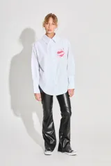 Pantalon de tiro alto confeccionado en ecocuero, con diseño semi oxford y cierre metálico lateral. Presenta un recorte horizontal sobre la rodilla.