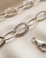 Pulsera de plata 925 con diseño de eslabones ovalados entrelazados, algunos de ellos con detalles texturizados.