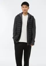 Chaleco puffer negro con cierre frontal, cuello alto y diseño acolchado horizontal.