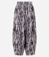 Pantalón aladín de cintura alta confeccionado en viscosa texturizada con estampado tie-dye en tonos oscuros. Presenta un corte amplio con volumen en las piernas y bajos afinados.