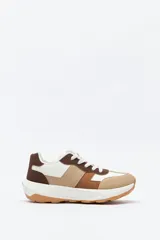 Zapatilla urbana de diseño contemporáneo con capellada que combina paneles de diferentes texturas en color negro, ajuste con cordones y suela robusta de color blanco.