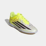 Championes de fútbol sala Adidas F50 Club, con diseño ligero en color amarillo neón y blanco. Presentan las icónicas tres tiras de la marca en negro con bordes rojos en el lateral, suela de goma color caramelo tipo non-marking y cierre de cordones.