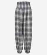 Pantalón de viscosa estilo aladín con estampado a cuadros en tonos grises, blancos y azules. Presenta cintura elástica fruncida y puños ajustados en los tobillos de corte ancho.