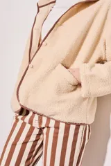 Campera beige de corderito vegano con cuello mao y cierre frontal con botones a presión.