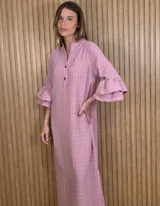 Vestido midi tipo túnica color rosado con sutil patrón a cuadros, escote en V con cuello mao y cierre frontal parcial con dos botones oscuros. Mangas tres cuartos terminadas en doble volados amplios.