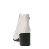 Botas de caña baja marca Bottero, confeccionadas en cuero color marfil, con taco cuadrado negro y punta redondeada.