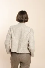 Chaqueta de sastrería color crema, entallada y con cuello erguido. Prenda forrada de lana fina sin teñir.