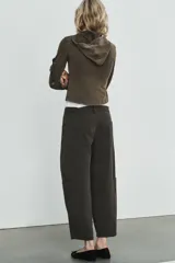 Pantalón cargo de tiro alto con corte holgado y diseño de volumen. Presenta bolsillos laterales tipo cargo, bolsillos frontales clásicos y cierre frontal con cremallera y botón.