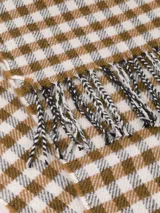 Bufanda de tejido suave con diseño de cuadros vichy en blanco y negro, terminada con flecos en los extremos.