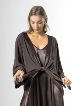 Kimono confeccionado en tejido liviano color marrón chocolate, con bordes satinados y mangas amplias. Puede usarse abierto o cerrado mediante un nudo al frente.