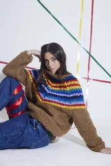 Sweater tejido a mano en lana merino color marrón con cuello redondo y diseño de rayas horizontales de colores en la parte superior. De calce holgado con cuello a la base y puños.