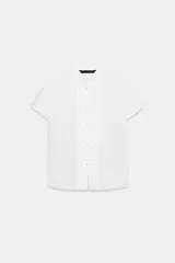 Camisa entallada de color celeste, con cuello mao y manga corta. Presenta un cierre frontal con alamares decorativos.