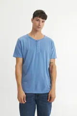 Remera de algodón color beige con cuello redondo y cierre frontal parcial con botones, de manga corta y corte clásico.