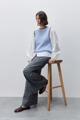 Chaleco de punto calado color celeste con cuello redondo y terminaciones en contraste marrón, de silueta cómoda y diseño sin mangas.