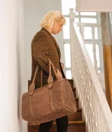 Bolso de mano tipo shopper marca Amadea, confeccionado en cuero con acabado desgastado. Presenta detalles de costuras decorativas verticales, correas con hebillas metálicas doradas y logo grabado al frente.