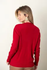 Sweater rojo de punto con cuello redondo, mangas largas, trenzado central y bolsillos delanteros.