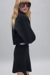 Jersey de punto corto con diseño de cuadros, cuello barco y mangas largas acampanadas.