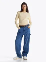 Zapatillas Tommy Jeans de corte bajo, color gris claro, confeccionadas en ante con interior de poliéster y suela de goma color caramelo. Presentan cordones blancos, logo de la marca en la lengüeta y etiqueta de Tommy Jeans en el lateral.