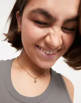 Dije charm bañado en oro amarillo 18k con cristal rosa en forma de ojo.