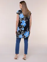 Túnica de gasa negra con estampado floral en tonos azules y blancos, cuello camisero, manga corta y cierre frontal de botones.
