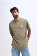 Remera de manga corta color verde militar con textura sutil y pequeña estampa discreta en el pecho.