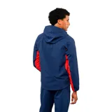 Campera deportiva con capucha, diseño tricolor en azul, rojo y blanco. Cuenta con cierre frontal completo, bolsillos laterales con cierre y el escudo del Club Nacional de Football junto al logo de Umbro en el pecho.