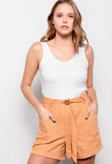 Short color naranja de lino con lazo en la cintura, bolsillos en el frente y terminación inferior arremangada.