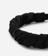 Vincha femenina revestida en tejido de poliéster con diseño fruncido y torcido que aporta volumen y textura. Cuenta con extremos cubiertos para mayor comodidad.