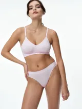 Bralette seamless de microfibra color blanco, con diseño de escote en V, sin relleno y sin aros. Presenta breteles finos ajustables y una banda elástica inferior con textura acanalada.