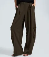 Pantalón sastre de corte barrel, con diseño de piernas anchas y volumen estructurado en los laterales. Presenta pliegues frontales, cintura con elástico en la parte posterior y acabado refinado.