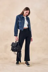 Pantalón negro de tiro alto, corte acampanado (flare) y tejido acanalado (rib).