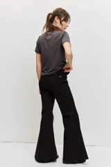 Pantalón negro de corte flare, tiro alto y diseño ajustado en la parte superior con piernas acampanadas.