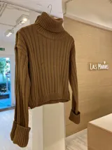 Sweater marrón de punto con cuello alto y mangas largas con puños anchos.
