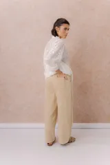Pantalón de denim liviano color beige, de calce amplio y relajado con pierna recta. Cuenta con cintura elastizada, cordón regulable, bolsillos laterales y costuras delanteras verticales que estilizan la silueta.