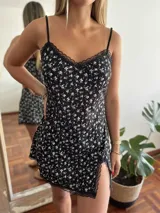 Camisolín corto negro con estampado de pequeñas flores blancas, breteles finos y detalles de encaje en escote y ruedo.
