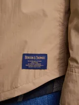 Campera casual liviana de nylon, con cierre frontal de botones a presión, cuello camisero y bolsillos frontales tipo parche.