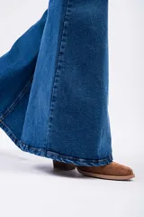 Pantalón de jean estilo Oxford de tiro alto, con ajuste en muslos y corte acampanado en la parte inferior. Presenta un lavado azul clásico y costuras reforzadas.