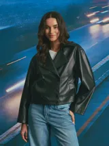 Chaqueta corta de cuero sintético en color negro, con diseño de doble botonadura, solapas amplias y corte holgado.