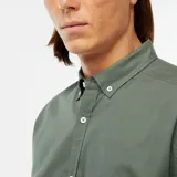 Camisa de corte regular fit en tejido oxford color verde, con cuello abotonado y cierre frontal de botones.